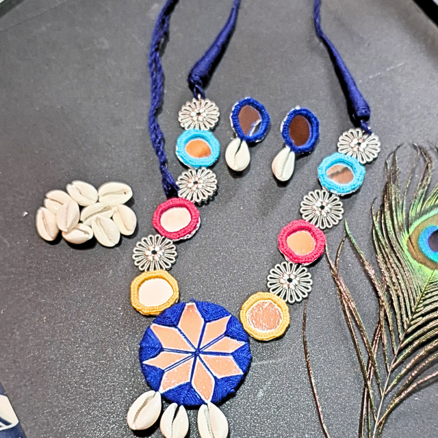 Handcrafted shell and mirror necklace set with colorful threadwork and peacock feather