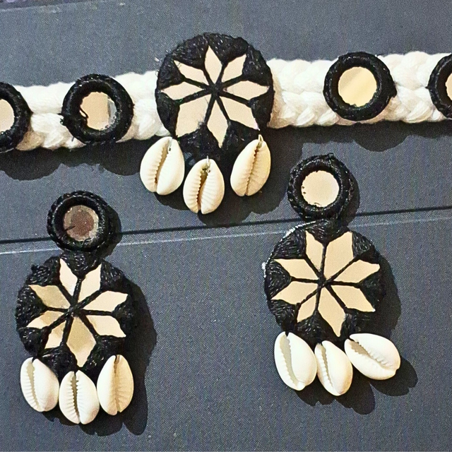 Handcrafted jewelry set with cowrie shells, mirrors, and black and beige geometric patterns