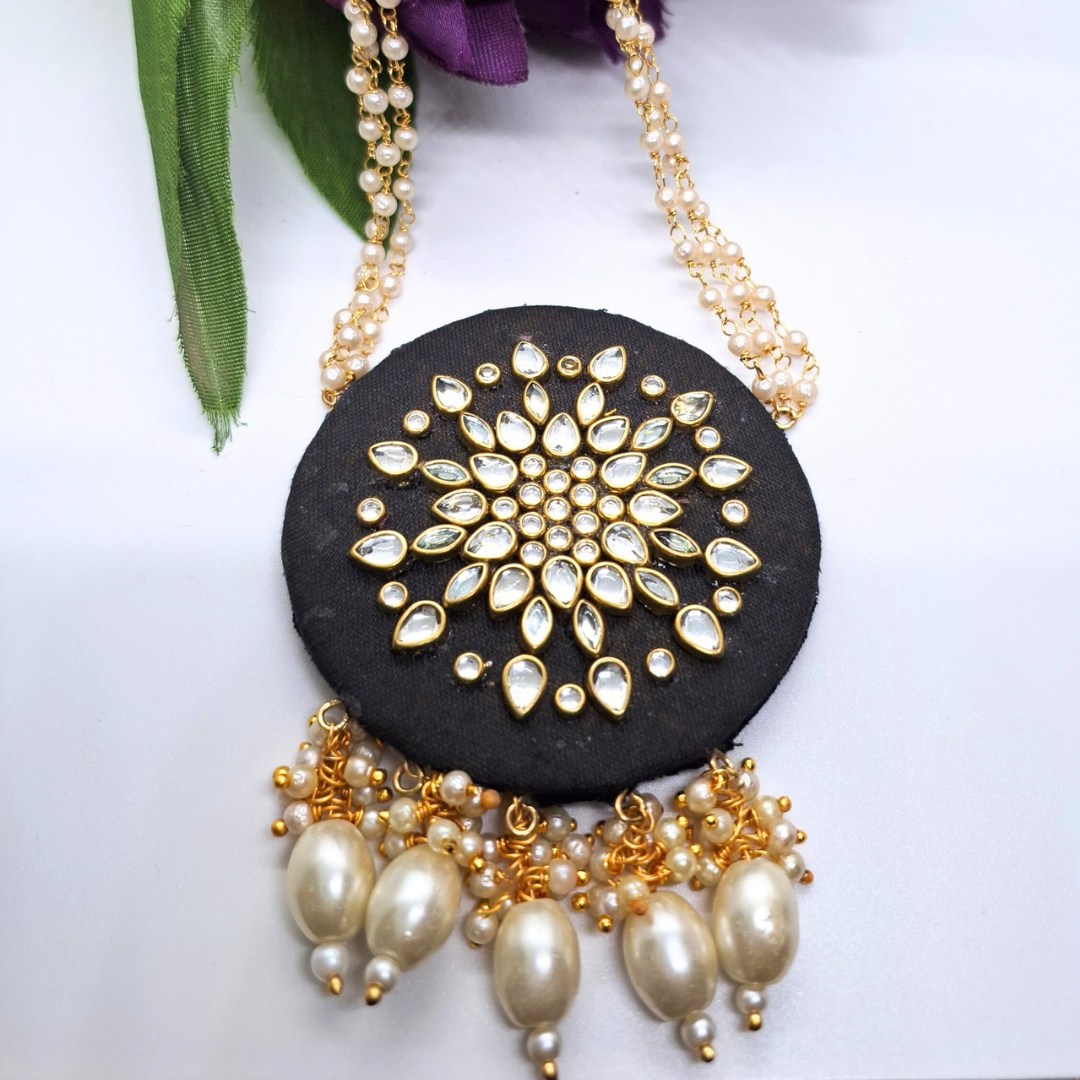 Traditional black and gold pendant necklace with pearl and crystal floral design accents.