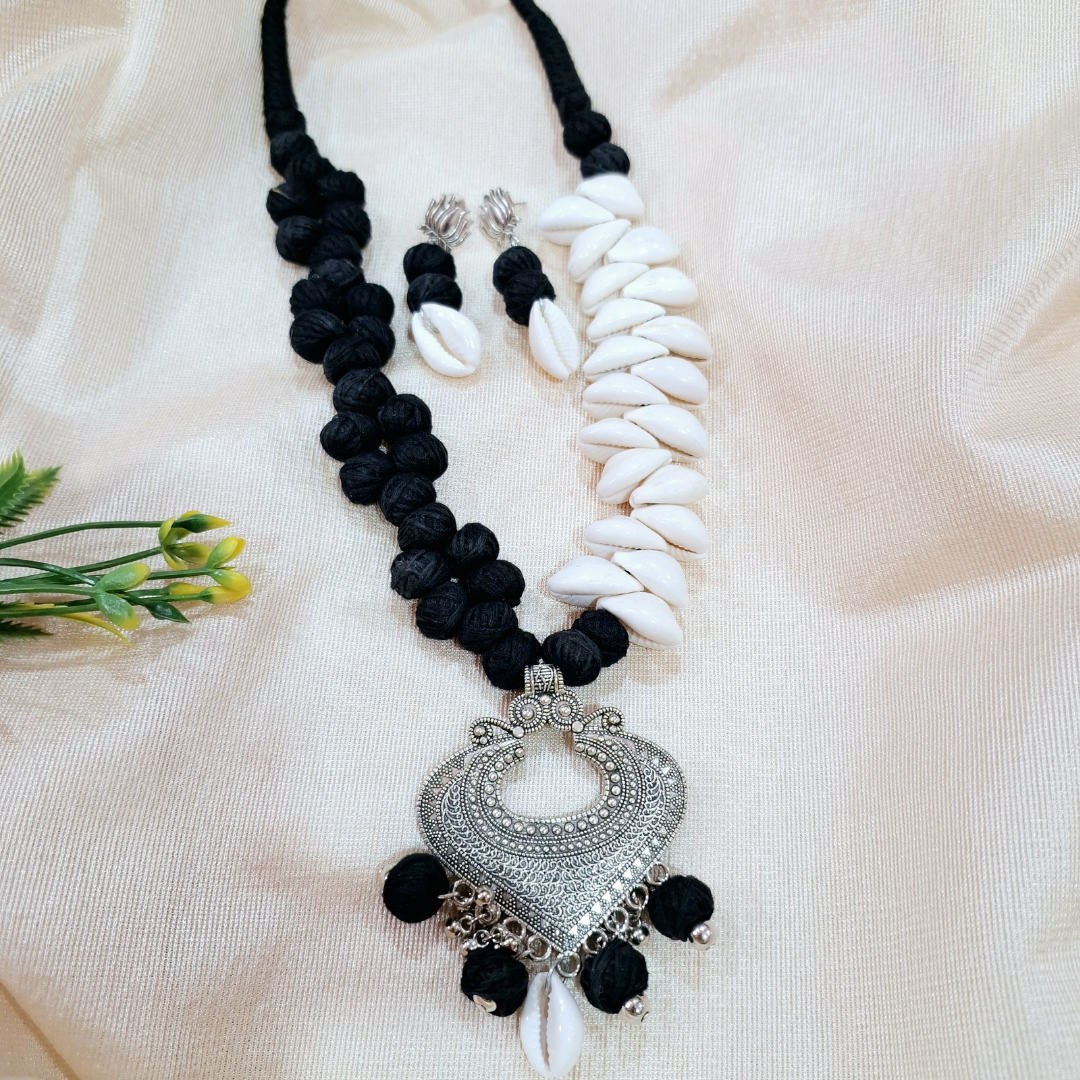 Handcrafted black and white shell and fabric necklace set with ornate silver pendant and earrings
